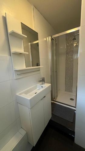 a white bathroom with a sink and a shower at Economic room Sheperds Bush - hotel-like room in London