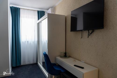 a room with a desk and a tv on the wall at Pensiunea Paradis Buzias in Buziaş