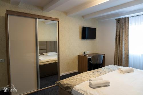 a hotel room with two beds and a mirror at Pensiunea Paradis Buzias in Buziaş