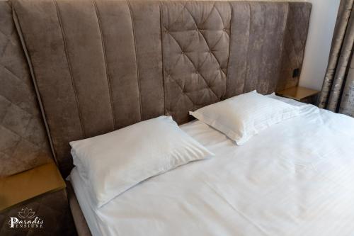 a bed with two white pillows on top of it at Pensiunea Paradis Buzias in Buziaş