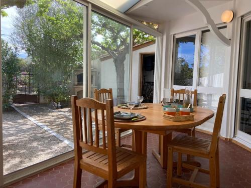 une salle à manger avec une table et des chaises en bois dans l'établissement Maison en bord de mer au Village des Sables, à Torreilles