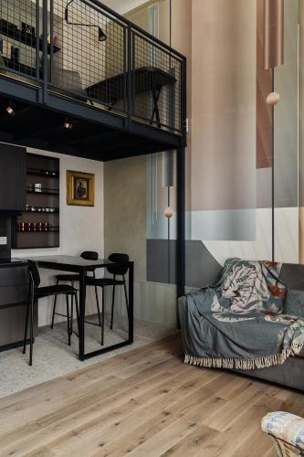 a room with a bed and a dining table and a loft at Bellevue Bocconi Suite in Milan