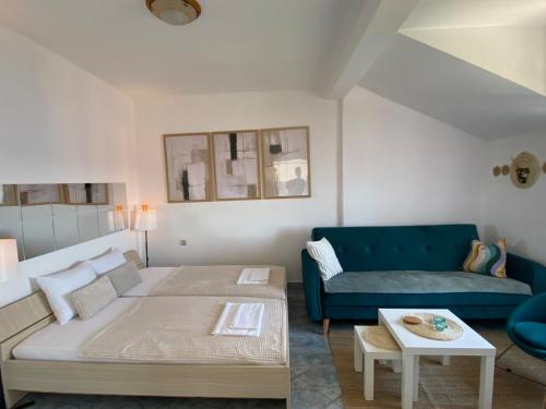 a living room with a bed and a blue couch at Saint Sunday in Kamenari