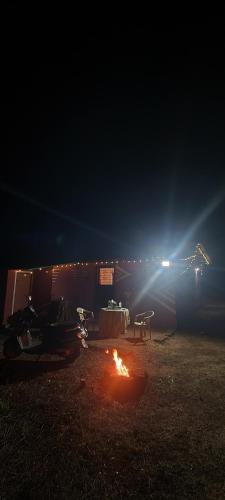 a table and a fire in a field at night at Pratishant Village Home Stay & Agro Tourism in Jāmb