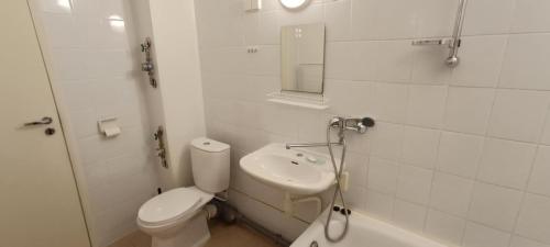 a white bathroom with a toilet and a sink at Kapteni kodu in Paldiski