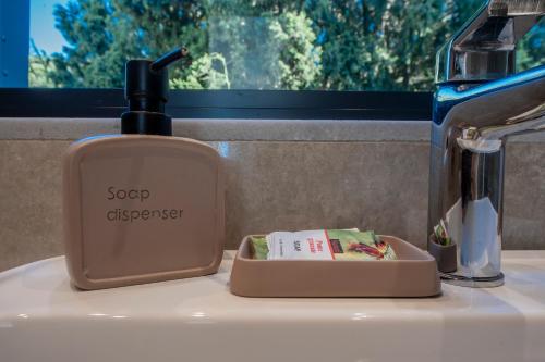 a soap dispenser sitting on top of a sink at The Gem Loft City Apartment in Rhodes Town