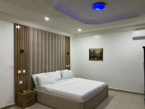 ein Schlafzimmer mit einem Bett mit blauer Decke in der Unterkunft Events & Suites in Abuja