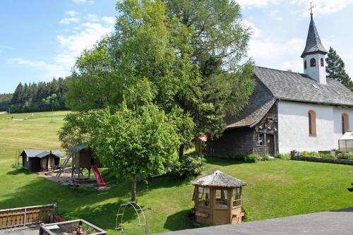 an old church with a playground in front of it at Gasthaus Heiligenbrunnen in Titisee-Neustadt