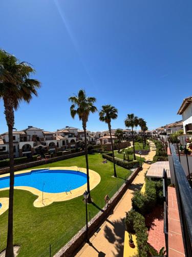 vista su un parco con piscina e palme di El Ático de Vera a Vera