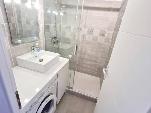 une salle de bain blanche avec un lavabo et une douche dans l'établissement T3 climatisé avec piscine, tennis et parking à 200m des plages - FR-1-316-252, à Six-Fours-les-Plages