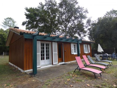 LesperonにあるBruyeresのピンクの椅子が置かれた小さな小屋