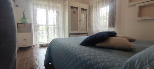 a woman laying on a bed in a bedroom with windows at La Torre Guest House in Anguillara Sabazia