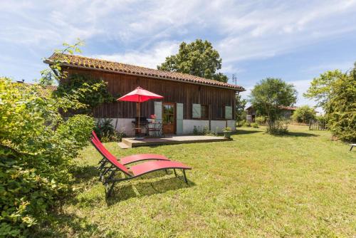 a red bench sitting in front of a house at Gite du platane in Bélis