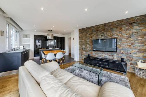 - un salon avec un canapé blanc et un mur en briques dans l'établissement Le Balzac- 2 chambres - Proche Place de Bretagne, à Rennes