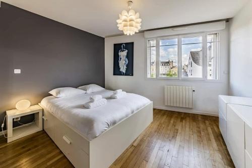 une chambre avec un lit blanc et une fenêtre dans l'établissement Le Balzac- 2 chambres - Proche Place de Bretagne, à Rennes