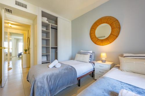 a bedroom with two beds and a mirror at FINALBIR MIMAR- Vistas al mar-Sea view- parking in Albir