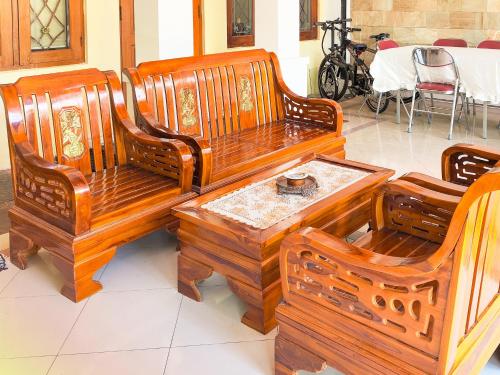 a group of wooden benches and a table at Palma Villa Homestay Klaten in Kuwoso