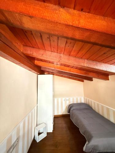 a bed in a room with wooden ceilings at Tesoro di Alarico in Cosenza