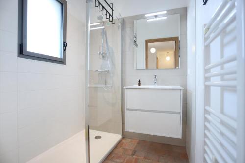 une salle de bain blanche avec un lavabo et un miroir dans l'établissement Bonne rencontre, à Saint-Malo