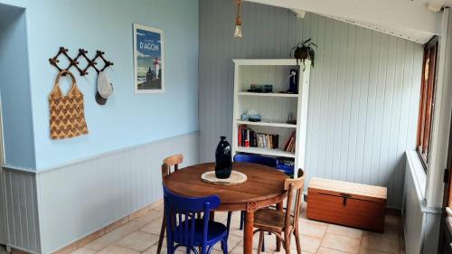 a dining room with a wooden table and chairs at Maison cosy & jardin privé Plages à 5 min in Tourville-sur-Sienne