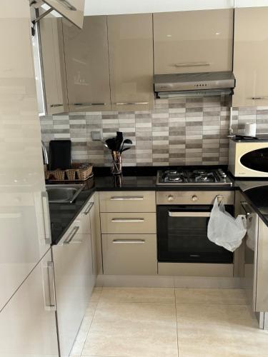 a kitchen with white cabinets and a stove top oven at Charming Private Residence with 6 swimming pools in Sahline