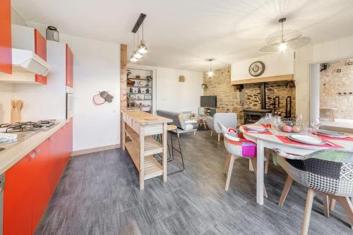 une cuisine et une salle à manger avec une table et des chaises dans l'établissement Beauregard - Jolie maison - Vue sur Rance - 4 pers, à Saint-Jouan-des-Guérets