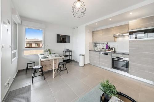 une grande cuisine avec une table et des chaises. dans l'établissement CANEPHORA - 800m mer, terrasse, parking, 400m gare, à Saint-Malo