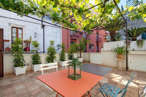 a patio with a table and potted plants at Dimore di Bacco in Rutigliano