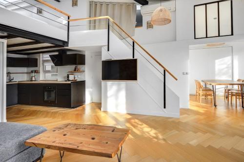 un salon avec un escalier et une table dans l'établissement Le Loft Montmartre, à Paris