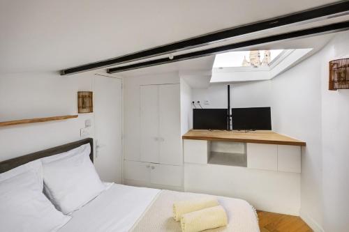 une chambre blanche avec un lit et une fenêtre dans l'établissement Le Loft Montmartre, à Paris