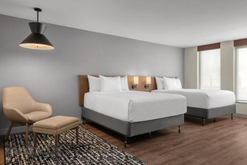 ミシサガにあるHyatt Place Mississauga / Airport Corp Centerのベッドルーム1室(ベッド2台、椅子、テーブル付)