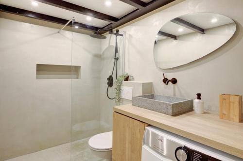 une salle de bain avec un lavabo, des toilettes et un miroir dans l'établissement Le Loft Montmartre, à Paris