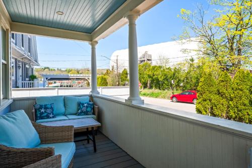 a porch with a couch and a table and chairs at Historic Seaside Downtown Mystic Home Walk to Seaport in Stonington