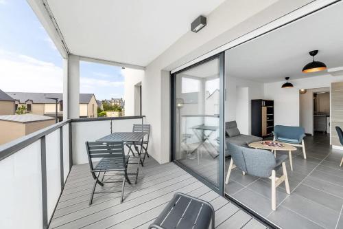 un balcon avec une table et des chaises et une cuisine dans l'établissement Carthage - Bel appartement - Proche plage, à Saint-Malo