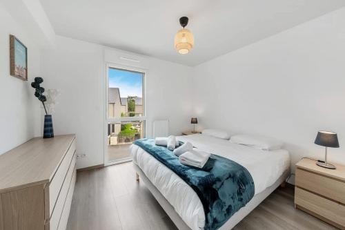 une chambre blanche avec un grand lit et une fenêtre dans l'établissement Carthage - Bel appartement - Proche plage, à Saint-Malo