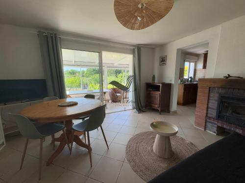 un salon avec une table et des chaises et une cheminée dans l'établissement Dans mon Verger - Agréable maison idéalement située, à Saint-Agnant