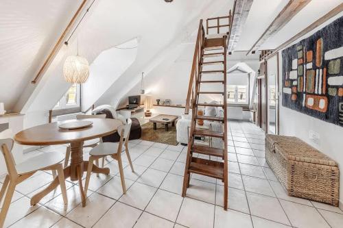 a dining room and living room with a wooden ladder at Le 38 - Studio atypique au coeur de Cancale-3 pers in Cancale