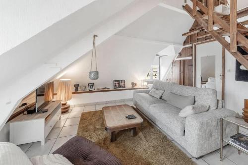 a living room with a couch and a table at Le 38 - Studio atypique au coeur de Cancale-3 pers in Cancale