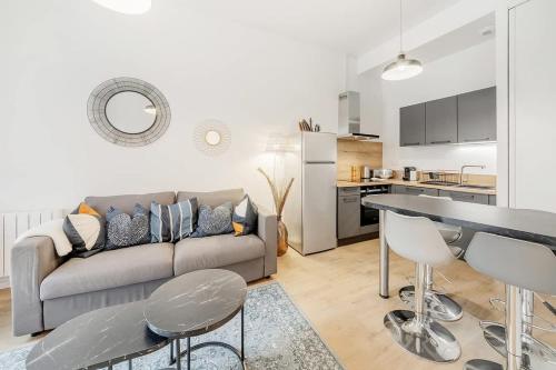 un salon avec un canapé et une cuisine dans l'établissement Le Saint Martin, bel appartement de standing, à Rennes