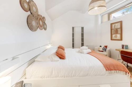 une chambre blanche avec un lit et un bureau dans l'établissement Le Saint Martin, bel appartement de standing, à Rennes