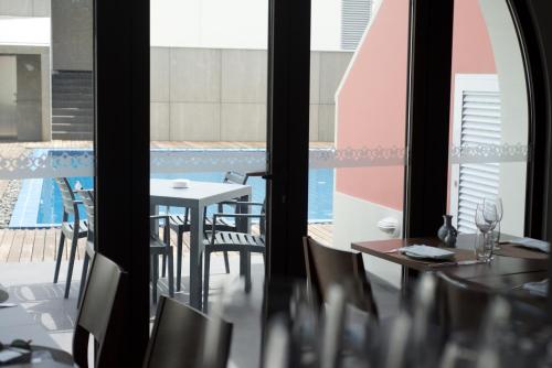 a room with a table and chairs and a pool at Charming Blue in Vila do Porto