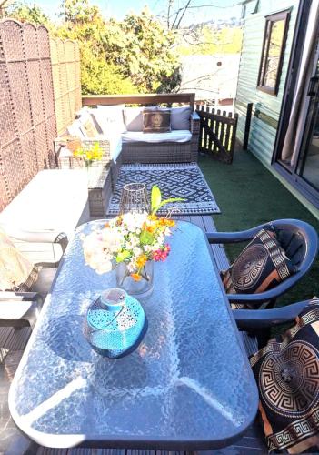 a blue table on a patio with flowers on it at Aberystwyth holiday village walking distance to beach, town great outside space parking next to property in Aberystwyth