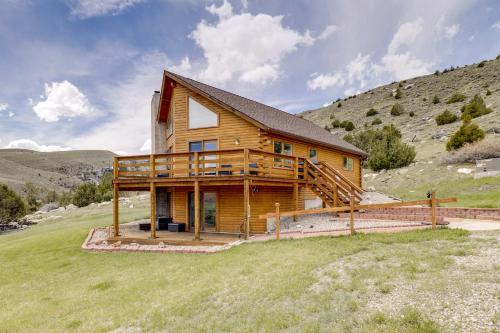a log cabin with a deck on a hill at Walk to Sinks Canyon State Park Spacious Home! in Lander