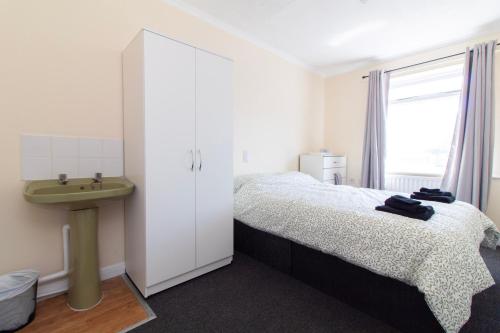 a bedroom with a bed and a sink and a window at Brookvale Guest House Room 11 in Southampton