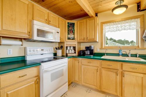 a kitchen with wooden cabinets and a white stove top oven at Walk to Sinks Canyon State Park Spacious Home! in Lander