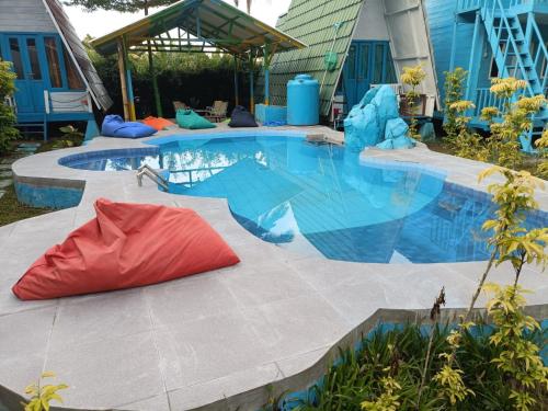 a large swimming pool with a red pillow next to it at Tanjong Tinggi Cottage in Sijuk