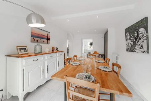 une salle à manger avec une longue table en bois et des chaises dans l'établissement Maison des Flots, 3 chambres, jardin, proche plage, à Saint-Coulomb