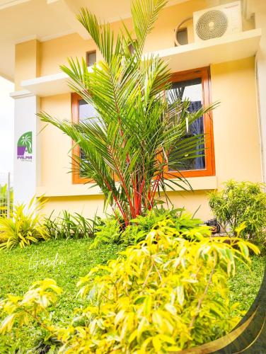 a palm tree in front of a building at Palma Villa Homestay Klaten in Kuwoso