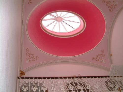 a room with a pink ceiling with a window at Terrace hotel in Edinburgh