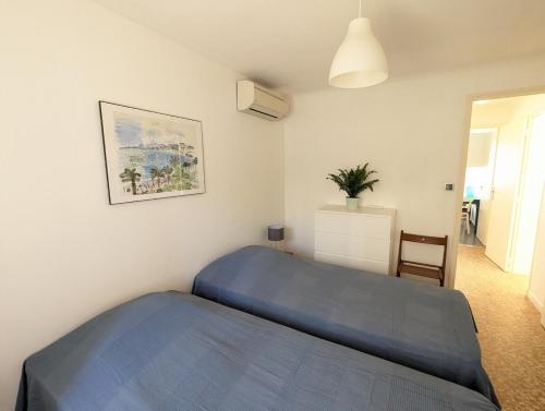 - une chambre avec un lit bleu et une chaise dans l'établissement Rez de villa, jardin, parking à 10 minutes de la plage, à Bandol